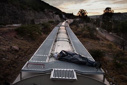 Irapuato, Estado de Guanajuato. Un hombre envuelto en un bolsa de plástico se protege del del frio y trata de descansar (eran las cinco de la madrugada) mientras viaja en el techo del tren de carga conocido como 'la Bestia' por los peligros que se enfrentan cuando se viaja en él. Los trenes de mercancías son los mas utilizados por los migrantes como medio de transporte para desplazarse hacia el norte de México. Viajar en ellos es muy peligroso. El riesgo de caerse o ser asaltado es muy alto. Desde 2010 recorrí varias rutas en trenes. Es un viaje duro, tanto por los peligros como por las condiciones climáticas y la falta de comida y agua. Aunque el miedo por lo que me podía pasar siempre me acompañó, la increíble relación que establecí con muchos de los migrantes, mis compañeros de viaje, me permitió sentirme seguro, protegido. Compartir mis historias, y ellos las suyas conmigo, es probablemente lo mas valioso de este proyecto.