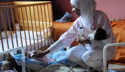 Una enfermera atiende a varios niños en un orfanato de Marruecos.