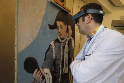 El restaurador Enrique Rodríguez observa 'Arlequín con espejo' en el taller del Thyssen.