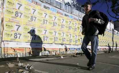 Un hombre pasea por una calle de Bogot&aacute; con carteles electorales
