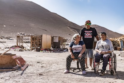 Manuela Medina (izquierda) junto a su familia, cerca de una pila de ropa en el desierto de Atacama.