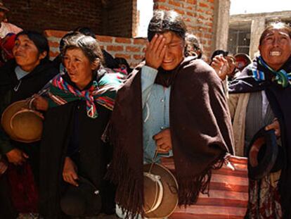 Familiares del alcalde linchado en Ilave (Perú) lloran ante la casa del regidor, en abril pasado.