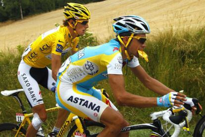 Schleck y Contador, que aprovecha un momento de calma para comer, durante la etapa de ayer.