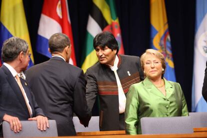 El expresidente de Estados Unidos Barack Obama estrecha la mano a Morales, durante la ceremonia de apertura de la Quinta Cumbre de las Américas en Puerto España, Trinidad y Tobago, el 17 de abril de 2009. A la derecha se encuentra la expresidenta de Chile, Michelle Bachelet.