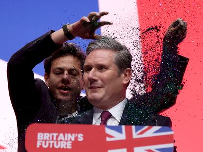 Un activista sube al estrado y arroja purpurina sobre el líder del Partido Laborista, Keir Starmer, este martes, durante el congreso que el partido celebra en Liverpool (Reino Unido).