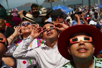 Personas observan el eclipse en Mazatlán, el primer punto en de totalidad del eclipse de este lunes en todo el territorio continental de América del Norte.
