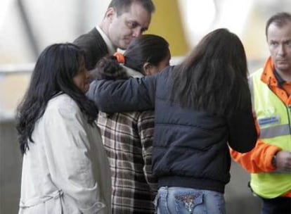 Allegados de las víctimas se abrazan en el aparcamiento de la terminal 4 de Barajas.