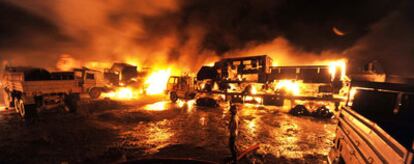 Un bombero paquistaní intenta extinguir el incendio del convoy de suministros para la OTAN atacado a las afueras de Islamabad.