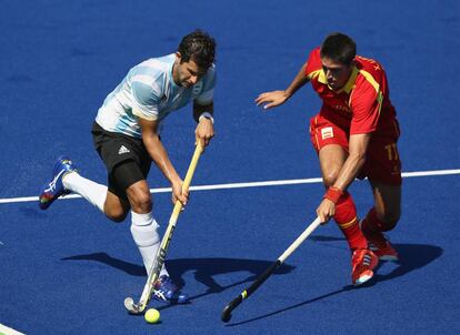 Juan López de Argentina, se mueve por delante de Xavi Lleonart, durante los cuartos de final de hockey masculino. España ha sido eliminada por los argentinos.