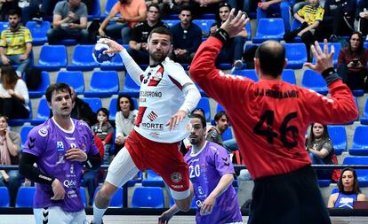 El jugador del Logroño La Rioja tira ante la oposición de Hombrados, portero del Guadalajara.