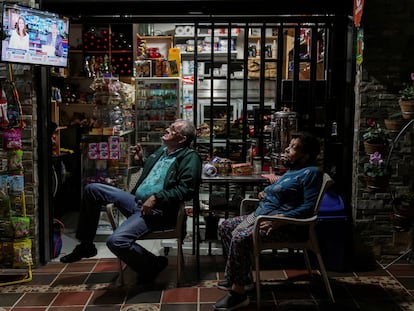 Dos personas miran una transmisión de televisión que muestra los resultados de la primera vuelta de las elecciones presidenciales, en Medellín, Colombia, el 29 de mayo de 2022.