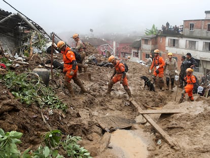 Rescatistas caminan en un sitio de un deslizamiento de tierra después de las lluvias torrenciales en Petrópolis, Brasil