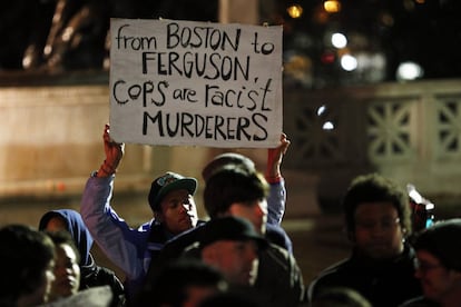 Vecinos de Boston protestan por la decisión del gran jurado. En la foto, un hombre sujeta un cartel en el que se lee "Desde Boston hasta Ferguson, los policías son asesinos racistas".