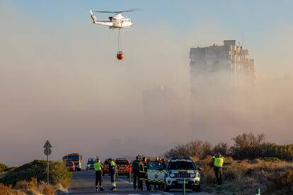 Un helicóptero trabaja en las labores de extinción del incendio forestal declarado a primera hora de la tarde de este lunes en El Saler, en Valencia, que ha obligado a desalojar preventivamente varios edificios.