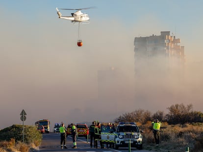 Un helicóptero trabaja en las labores de extinción del incendio forestal declarado a primera hora de la tarde de este lunes en El Saler, en Valencia, que ha obligado a desalojar preventivamente varios edificios.