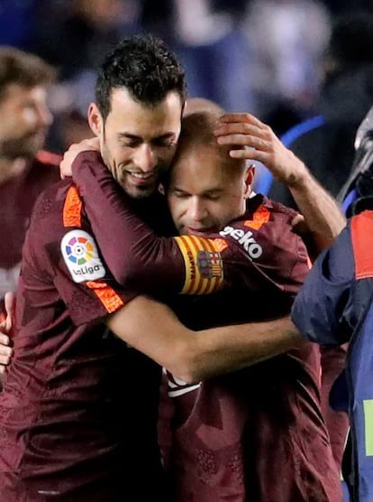 Los jugadores del FC Barcelona Sergio Busquets (i) y Andrés Iniesta celebran el título tras su victoria ante el Deportivo de Las Coruña, al término del partido de Liga en Primera División disputado esta noche en el estadio de Riazor. 