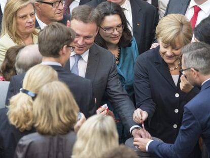 La canciller alemana, Angela Merkel (en el centro, a la derecha), y el ministro de Trabajo, Andrea Nahles (a su izquierda), votan la implantaci&oacute;n del salario m&iacute;nimo interprofesional en Alemania en el la c&aacute;mara baja del Parlamento alem&aacute;n (Bundestag)