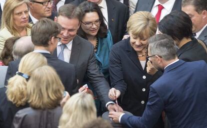 La canciller alemana, Angela Merkel (en el centro, a la derecha), y el ministro de Trabajo, Andrea Nahles (a su izquierda), votan la implantaci&oacute;n del salario m&iacute;nimo interprofesional en Alemania en el la c&aacute;mara baja del Parlamento alem&aacute;n (Bundestag)