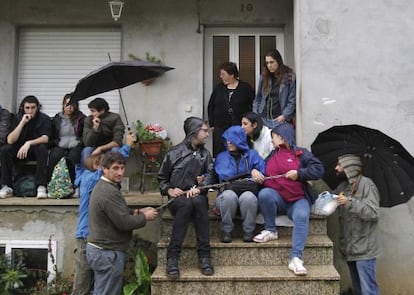 Varias personas se reúnen junto a la vivienda de una familia desahuciada el pasado día 19 en la parroquia santiaguesa de Aríns.