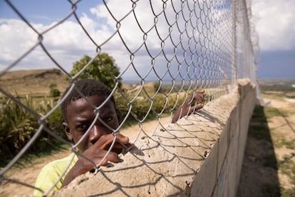Un joven haitiano se apoya en la verja perimetral que construye República Dominicana en la frontera con Haití, el pasado 8 de mayo.