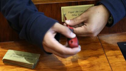 La cuarta y última votación decidirá el secretario tercero. En la imagen, un operario retira la placa de la consejera de Educación, Lucia Figar.