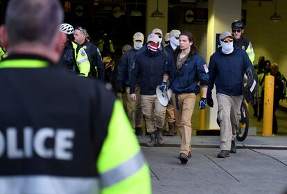 Police escort members of the Patriot Front from a parking garage, after they held a march near Capitol Hill, in Washington, in 2020.