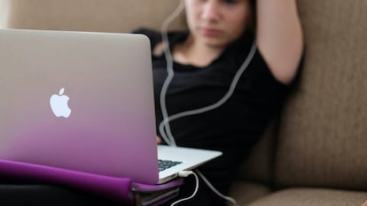 Una adolescente juega con su ordenador.