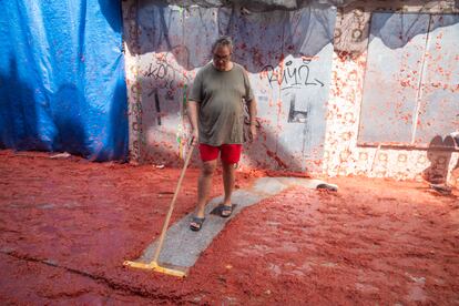 BUNOL, SPAIN - AUGUST 30: A neighbour starts cleaning his driveway while others continue to play with tomatoes on August 30, 2023 in Bunol, Spain. Spain's tomato throwing party in the streets of Bunol, Valencia brings together almost 20,000 people, with some 150,000 kilos of tomatoes thrown each year, this year with a backdrop of high food prices affected by Spain's historic drought. (Photo by Zowy Voeten/Getty Images)