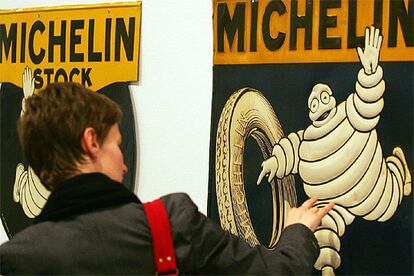 Una mujer contempla un cartel de Michelín durante la presentación en Valencia de la muestra <i>Nunc est Bibendum. Un mito gráfico desde 1898</i>.