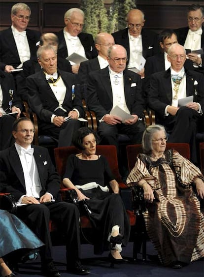 El estadounidense Jack Szostak, premiado en Fisiología y Medicina, la rumano-germana Herta Müller, Premio Nobel de Literatura (en el centro), y la estadounidense Elenor Ostrom, premiada en Economía, poco después de dar comienzo la ceremonia. Ostrom es la primera mujer que gana el Nobel de Economía.