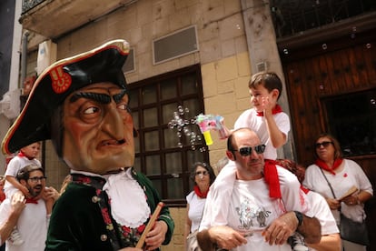 Un niño juega con su pistola de burbujas durante la "Comparsa de gigantes y cabezudos" en el festival de San Fermín.