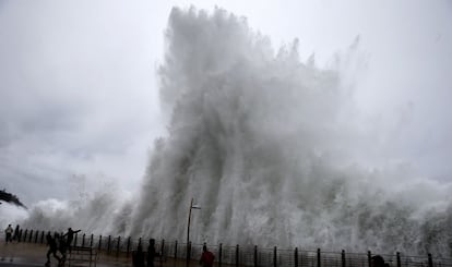 Varias personas huyen de una ola en el Paseo Nuevo de San Sebastián, cerrado al tráfico, donde se ha decretado la alerta naranja por fenómenos costeros.