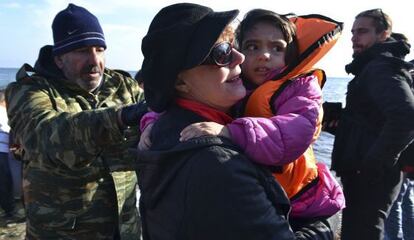 La actriz Susan Sarandon sostiene a un niño refugiado en la isla Lesbos. /