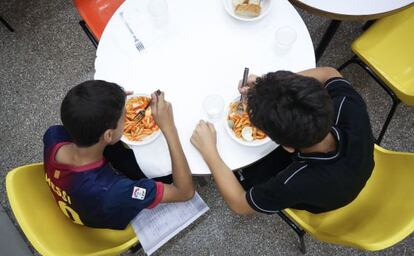 Dos ni&ntilde;os comen en un comedor social de Barcelona.