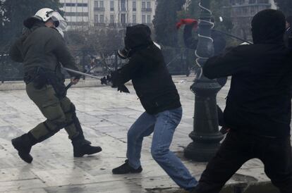 Un manifestante agrede a un policía griego durante la jornada de huelga general en la plaza Syntagma en Atenas (Grecia).