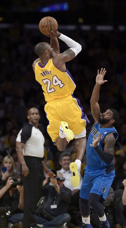 El jugador de los Lakers, Kobe Bryant (i), lanza el balón sobre O.J. Mayo de los Mavericks. Antes grabó un vídeo en homenaje a Shaquille que se emitió durante la ceremonia de retirada de su camiseta.