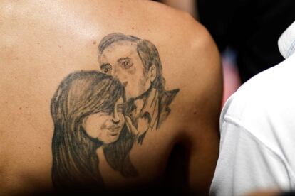 Un hombre muestra un tatuaje de Néstor Kirchner, presidente del país entre 2003 y 2007, fallecido en 2010, y su esposa, la expresidenta y nueva vicepresidenta, Cristina Fernández de Kirchner, durante los festejos afuera del Congreso argentino.
