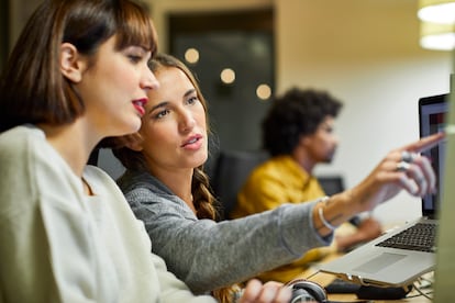 Dos mujeres jóvenes en una oficina.