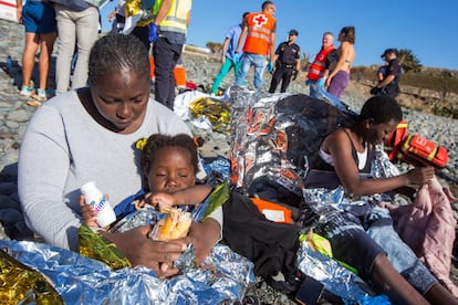 Una migrante alimenta a su hijo tras desembarcar en la playa de Águila.