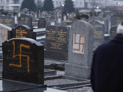 El l&iacute;der de una comunidad jud&iacute;a examina tumbas pintadas con la cruz gamada en un cementerio cerca de Estrasburgo en 2010.