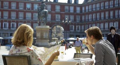 Una pareja de turistas tomando un café en la plaza Mayor.