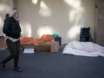 Una dona passa per davant de dos sensesostre a Barcelona.