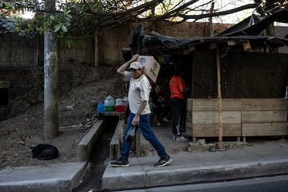 Un hombre camina con una caja de víveres en Nuevo Cuscatlán. El gobierno de Bukele, quién aquí ganó su primer cargo público electo como alcalde en 2012, entrega alimentos a los habitantes de este pueblo.