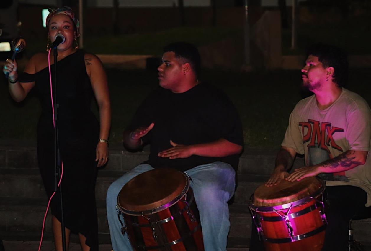 Un grupo de jóvenes toca bomba al caer la noche en Noches de Barrio. 