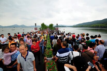 Turistas caminan por el puente de West Lake en Hangzhou, provincia de Zheijiang (China). 