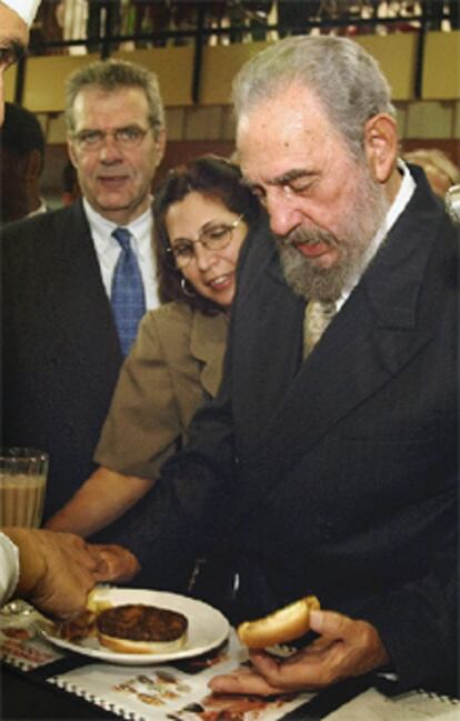 Fidel Castro observa una hamburguesa en la apertura de la feria.