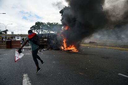 Un vehículo se incendia en medio de la autopista Francisco Fajardo, la vía que conecta oeste y este de Caracas, mientras manifestantes en contra del Gobierno de Nicolás Maduro cortan el tráfico en la vía.