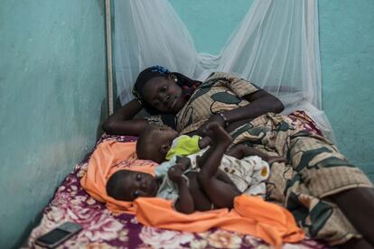Una mujer descansa junto a sus dos hijos aquejados de malnutrición en la Unidad Nutricional Intensiva del hospital de Dioila.