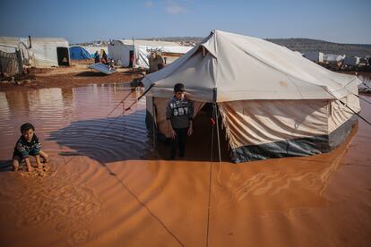 Dos niños en el campo de desplazados de Kafr Aruq, Siria, inundado en diciembre de 2020.