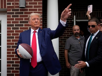 Former President Donald Trump holds a football before throwing it to the crowd during a visit to the Alpha Gamma Rho, agricultural fraternity, at Iowa State University before an NCAA college football game between Iowa State and Iowa, Saturday, Sept. 9, 2023, in Ames, Iowa. (AP Photo/Charlie Neibergall)